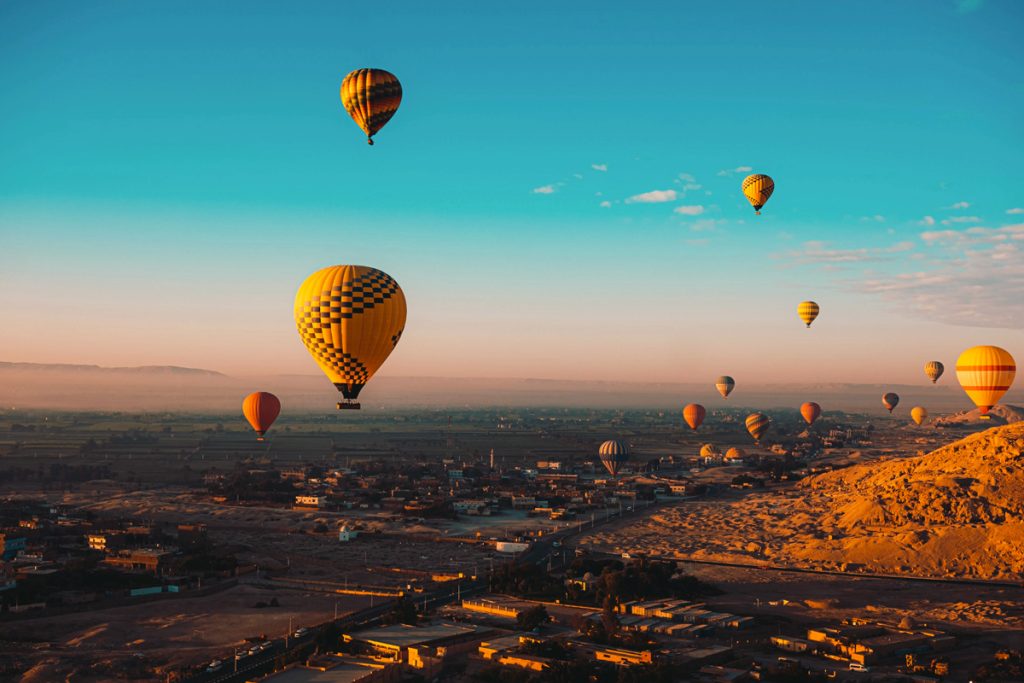 Hot air balloons drifting above Marrakech at sunrise